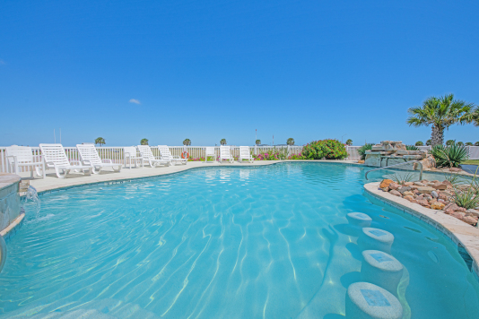 Community pool has built in barstools, plenty of loungers