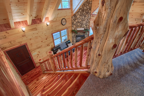 Looking down cedar log staircase, from Loft Level, to Main Entrance Door