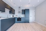 A spacious living room with a large TV, cosy sofas, and a fully equipped kitchen, ideal for relaxing and unwinding after a day of exploring.