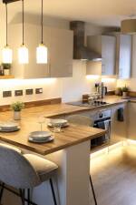 Well-lit kitchen with a cooker hood light and warm ambient task lighting.