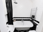 Elegant bathroom featuring a luxurious rolltop bath and a spacious shower for a relaxing experience.
