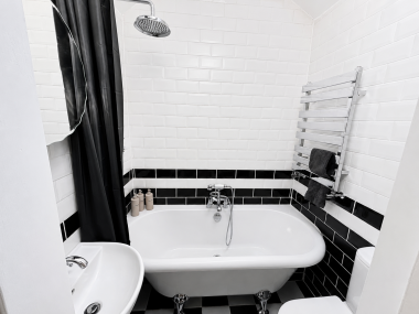Elegant bathroom featuring a luxurious rolltop bath and a spacious shower for a relaxing experience.