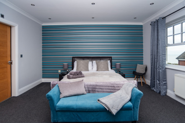 Spacious bedroom with a comfortable bed, a cosy sofa, and hotel-quality linens and towels provided throughout your stay.