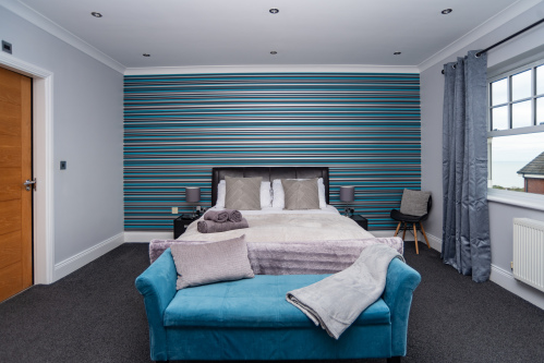 Spacious bedroom with a comfortable bed, a cosy sofa, and hotel-quality linens and towels provided throughout your stay.