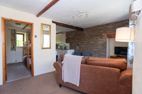 The bright open-plan living space blends traditional cottage character with modern comforts, creating a welcoming setting to relax after a day exploring.