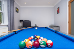 Games room with a full-size pool table, ideal for families, hen and stag groups, and coworkers looking to unwind during work breaks.