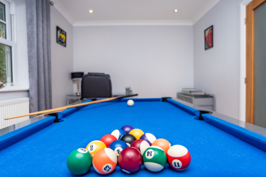 Games room with a full-size pool table, ideal for families, hen and stag groups, and coworkers looking to unwind during work breaks.