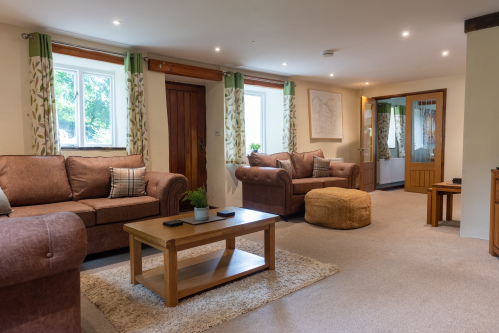 Room for Everyone to Relax - Multiple sofas, a local Devon map for planning your adventures, and direct access to the entertainment room with the 80-inch Smart TV.