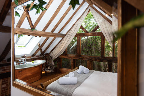 Treehouse-inspired upstairs bedroom with a copper freestanding bath, hotel-crisp linens, fresh towels and complimentary toiletries — come and unwind with us