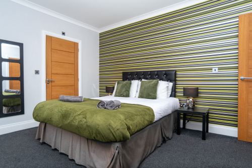 Spacious bedroom with a comfortable bed, a cosy sofa, and hotel-quality linens and towels provided throughout your stay.