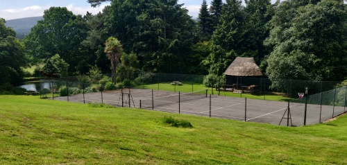 Tennis court grounds, thatched pavilion behind