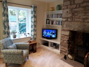Cosy lounge with feature stone fireplace and warming fire