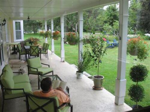 Our covered veranda is a great place to relax overlooking our expansive lawn and gardens.