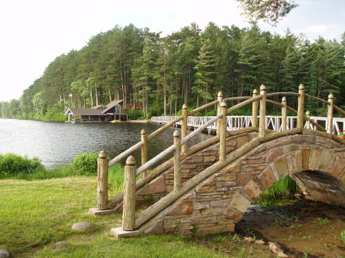 Stone bridge to the Teahouse island with the foot bridge and original guest boathouse in the distance