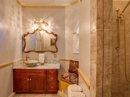 Palace Suite bathroom offering marble shower with dual shower heads and stone sink with marble counter.
