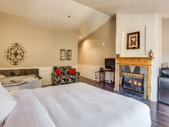 King Spa Suite with Pillowtop King Bed dressed in Luxurious Linens and Down Comforter, Gas Fireplace, Oversized Jetted Tub, Microwave, Mini Refrigerator and Coffeemaker.