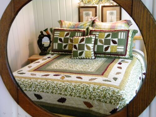 Carriage house suite 1 pine log queen bed with fall bedding.  The decor/bedding in suites is changed seasonally.