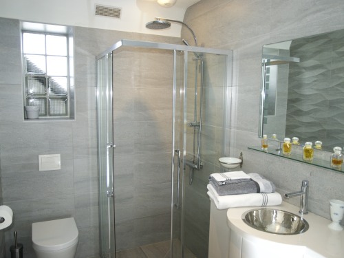 La salle de bains décorée dans un style épuré est dotée d'une douche à l'italienne.